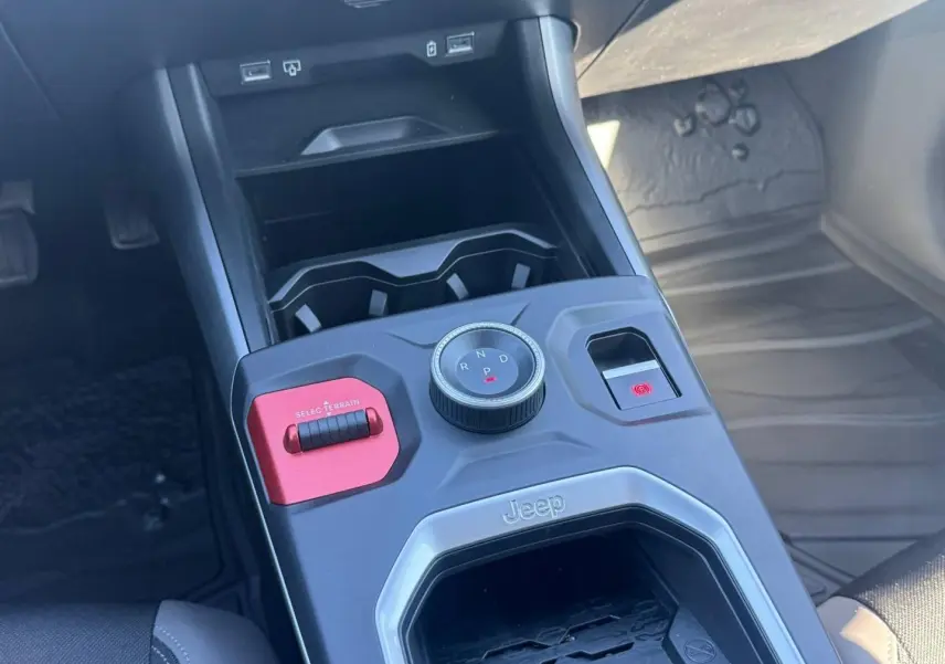Gros plan sur la console centrale du Jeep Compass 2026, avec molette de boîte auto et bouton Selec Terrain rouge.
