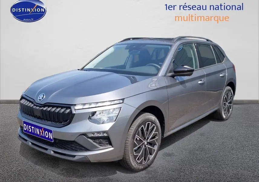 Vue 3/4 avant droite d'un Skoda Kamiq gris graphite 2025 avec calandre noire et jantes alliage distinctives.