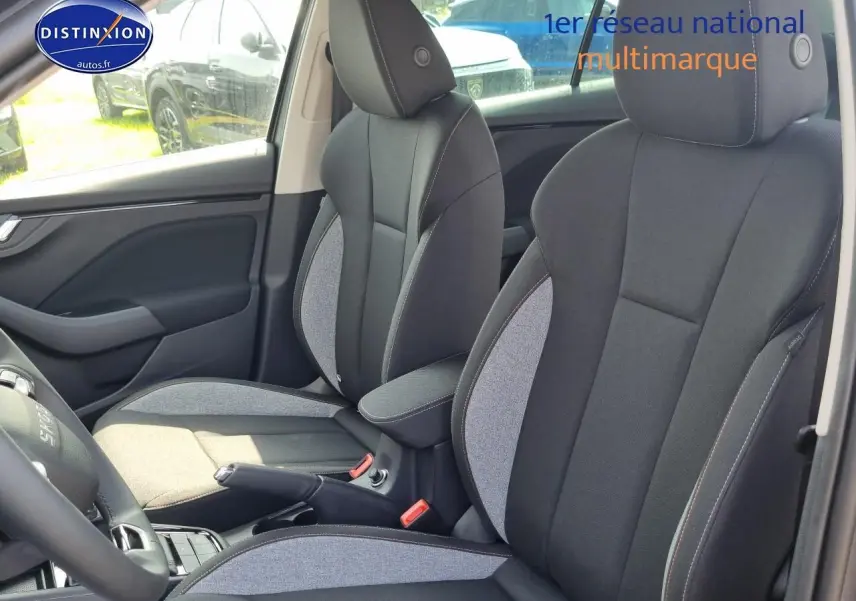 Intérieur SKODA KAMIQ 2025 montrant sièges avant bicolores gris et noir avec accoudoir central jumbo box.