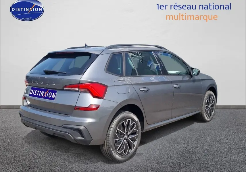 Vue 3/4 arrière droite d'un Skoda Kamiq gris graphite avec barres de toit noires et feux arrière LED.