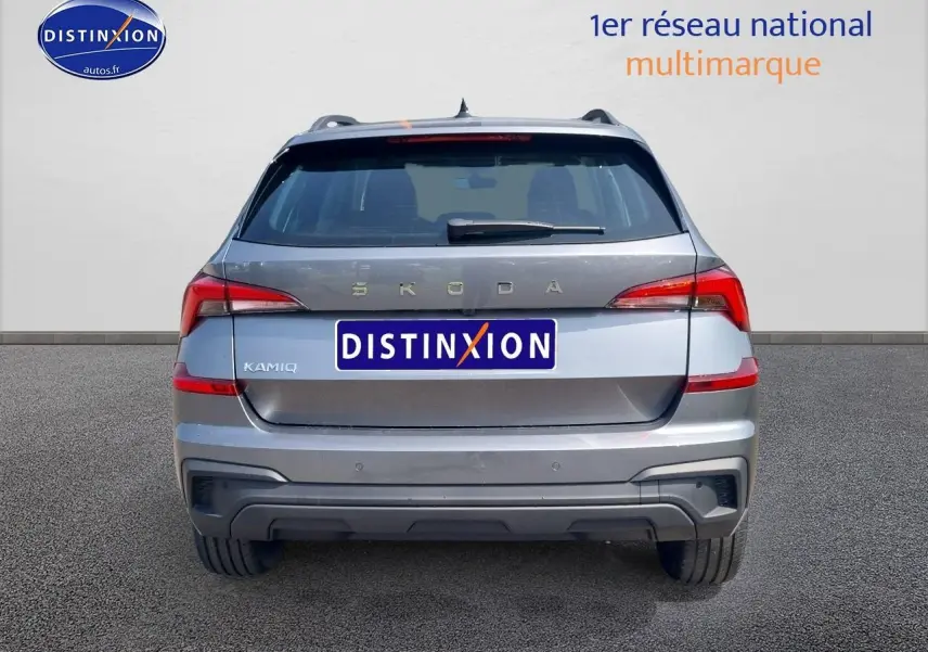 Vue arrière d'un Skoda Kamiq gris graphite 2025 avec feux LED et barres de toit noires visibles.
