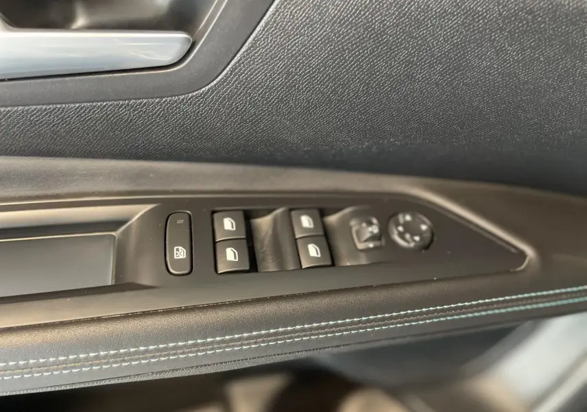 Panneau de porte côté gauche du Peugeot 5008 2024 avec commandes de vitres et réglage des rétroviseurs, surpiqûres bleues.