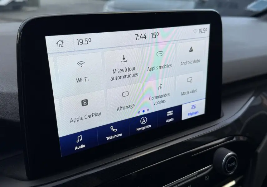 Écran tactile central du Ford Kuga 2022 affichant les réglages connectivité et commandes vocales, intérieur noir.