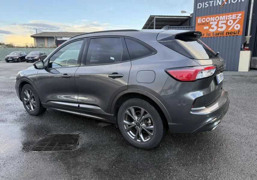Ford Kuga gris métallisé vu de profil côté gauche, avec vitres arrière surteintées et jantes alliage 18 pouces.