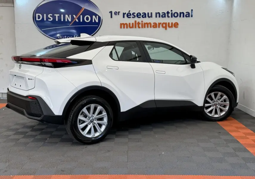 Vue latérale droite du Toyota C-HR 1.8 Hybride blanc 2024 avec lignes anguleuses et jantes alliage.