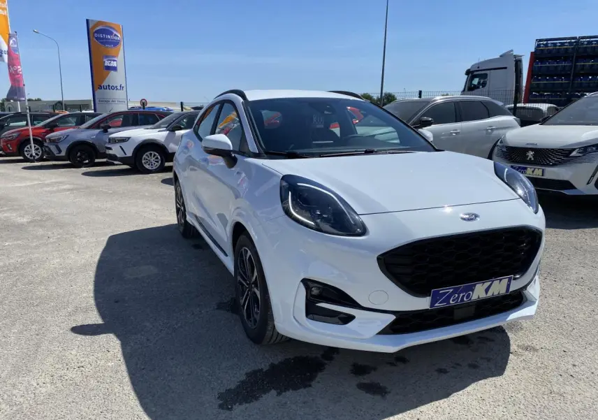 Ford Puma blanc glacier en 3/4 avant droit avec barres de toit noires et jantes alliage 17 pouces.