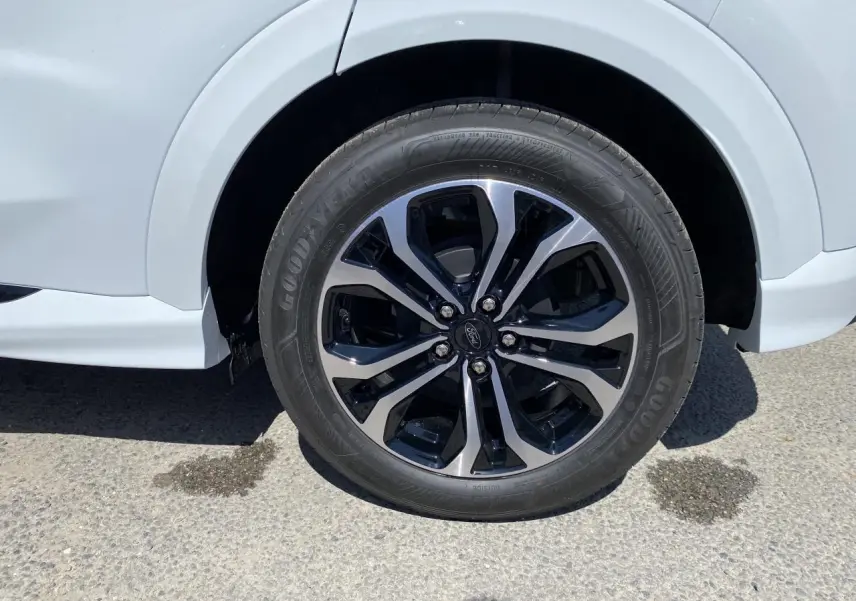 Gros plan sur la roue avant droite du Ford Puma blanc glacier avec jante alliage 17 pouces bicolore.