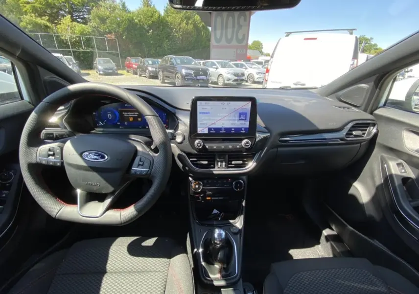 Vue intérieure avant du Ford Puma 2022, tableau de bord moderne avec écran tactile et volant multifonction noir.