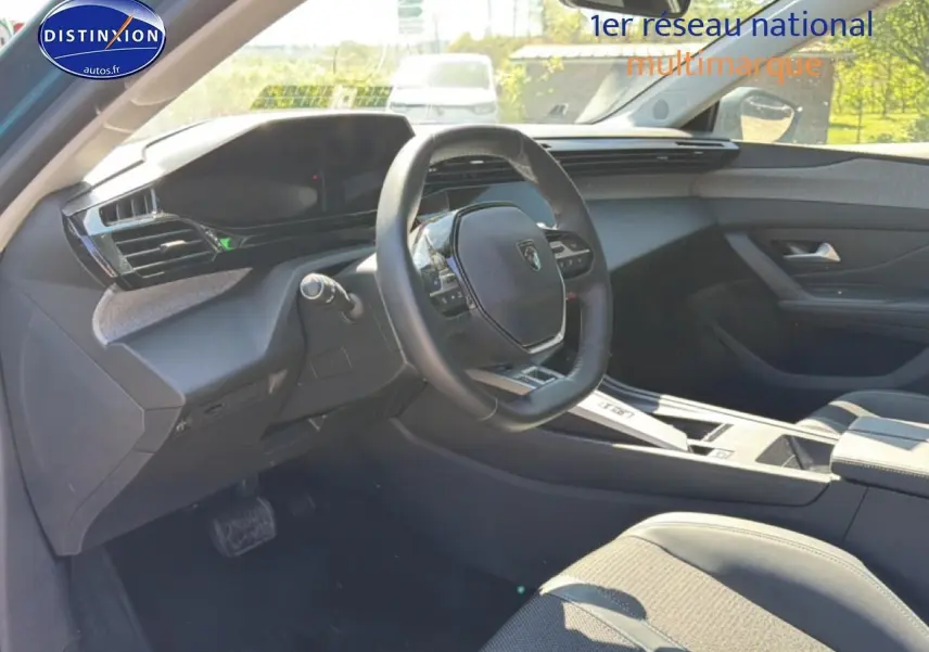 Vue intérieure côté conducteur du Peugeot 408 Hybrid bleu 2025, volant cuir et tableau de bord moderne.