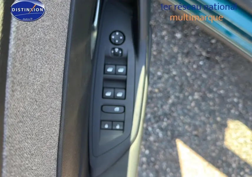 Vue rapprochée des commandes des vitres et rétroviseurs sur la porte avant gauche d'une Peugeot 408 bleu 2025.