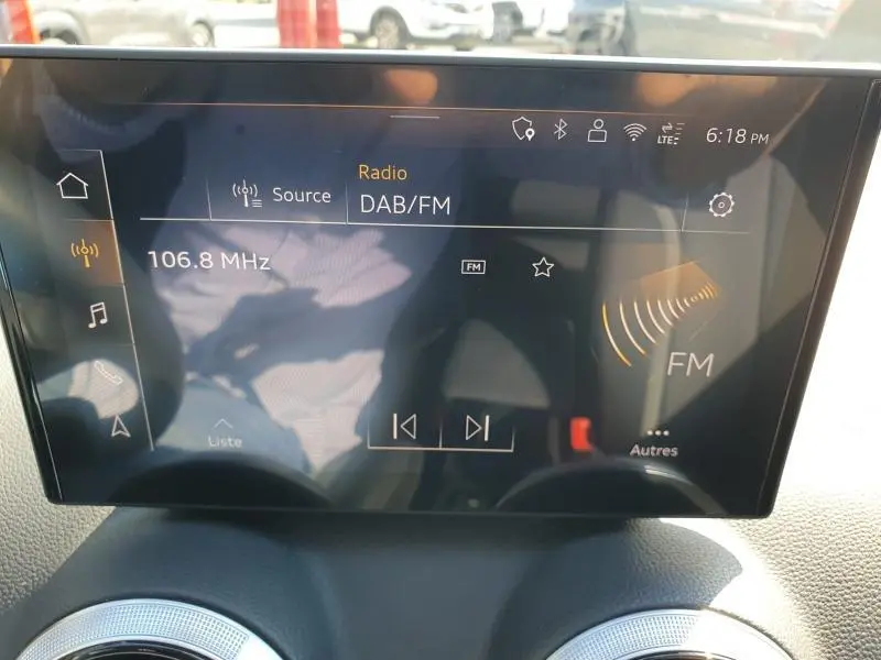 Écran tactile MMI navigation affichant la radio DAB/FM à 106.8 MHz dans un Audi Q2 gris Manhattan 2025.