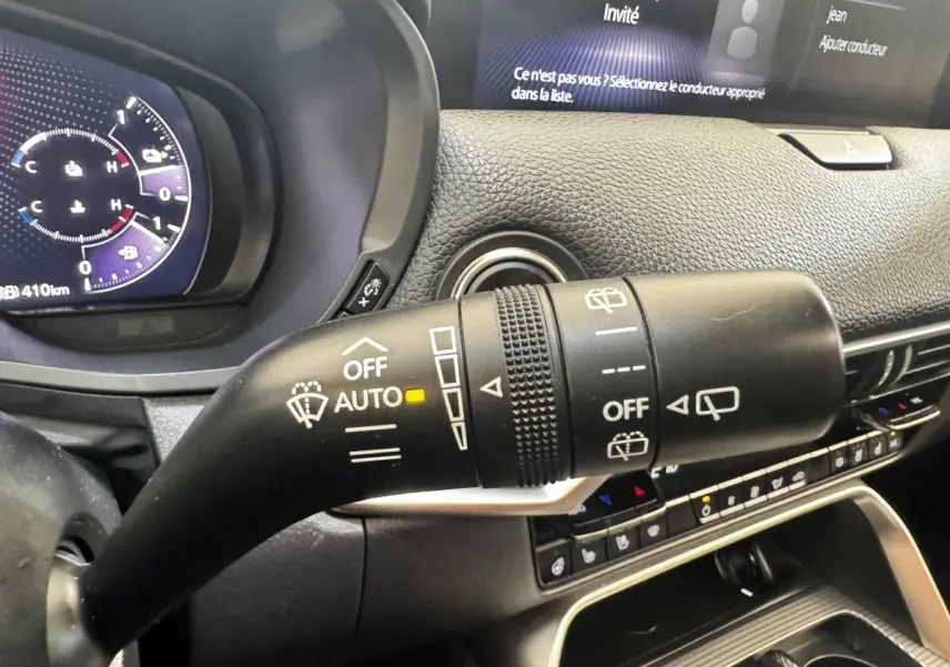 Gros plan sur la commande d’essuie-glace dans l’habitacle noir du Mazda CX-60 2024, tableau de bord et écran visibles.