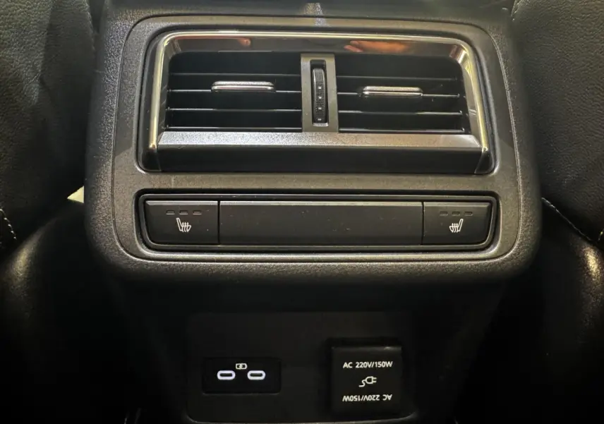 Vue rapprochée de la console arrière noire du Mazda CX-60 2024 avec aérateurs, commandes sièges chauffants et prises USB-C et AC.