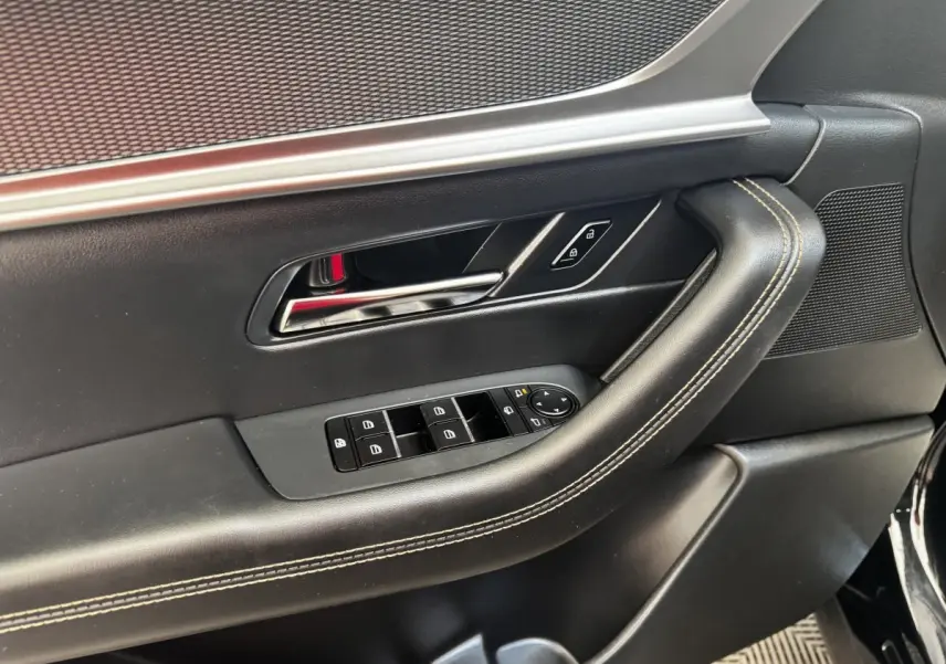 Gros plan sur la porte intérieure côté conducteur du Mazda CX-60 noir, avec commandes de vitres et verrouillage.