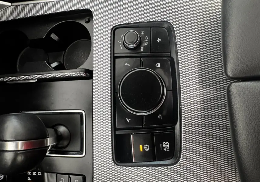 Vue rapprochée de la console centrale avec molette de sélection et levier de boîte automatique du Mazda CX-60 noir.