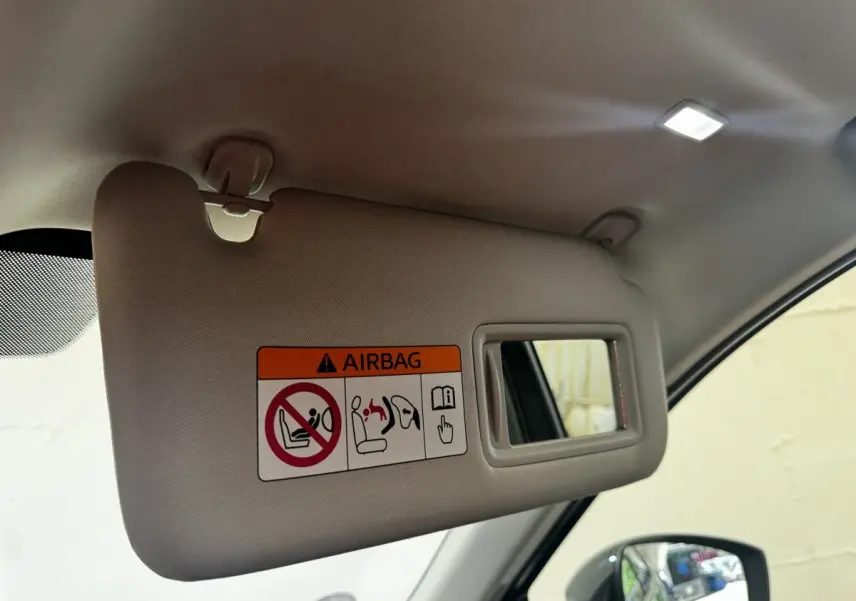 Détail du pare-soleil côté conducteur avec miroir et avertissement airbag dans un Mazda CX-60 noir 2024.