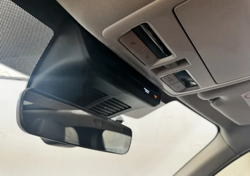 Vue intérieure rapprochée du rétroviseur et du plafonnier avec commandes lumineuses dans un Mazda CX-60 noir 2024.