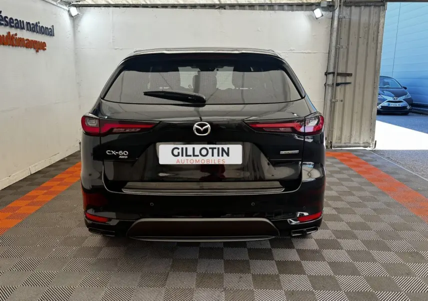 Vue arrière du Mazda CX-60 noir 2024 avec badges CX-60 AWD et e-Skyactiv PHEV, stationné en intérieur.