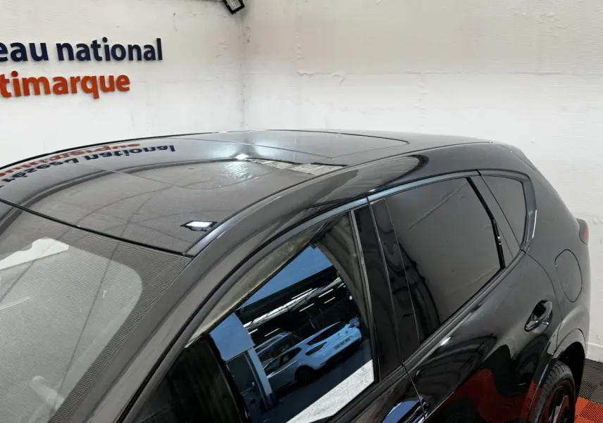 Vue partielle côté droit arrière du Mazda CX-60 noir 2024 avec toit panoramique et vitres teintées.
