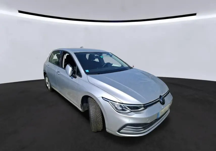 Volkswagen Golf gris clair vue 3/4 avant droit, mettant en valeur ses phares LED et sa calandre épurée.