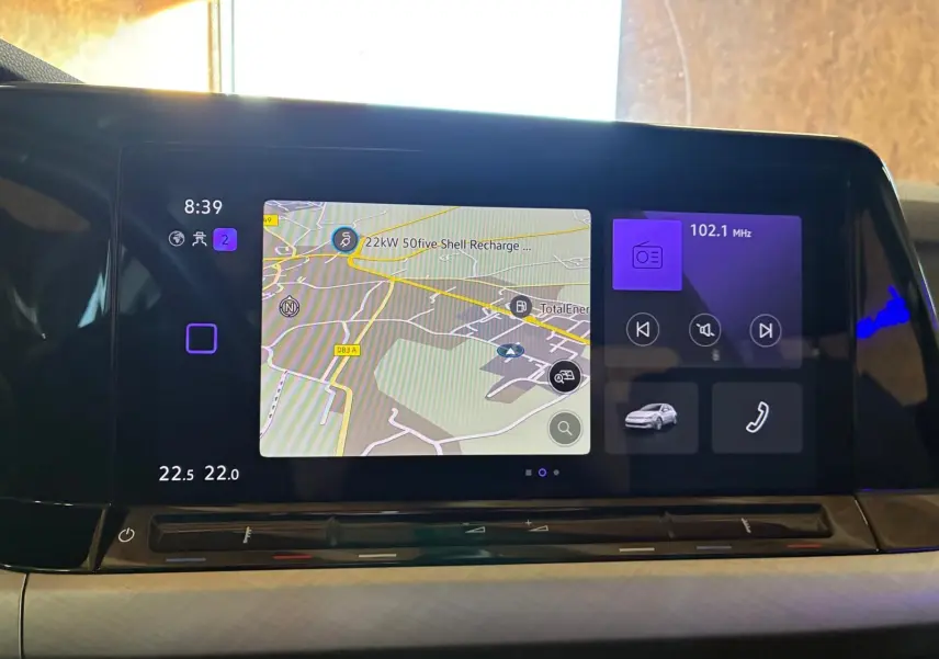 Écran tactile central de la Volkswagen Golf 2023 affichant navigation, radio et commandes multimédia, vue intérieure frontale.