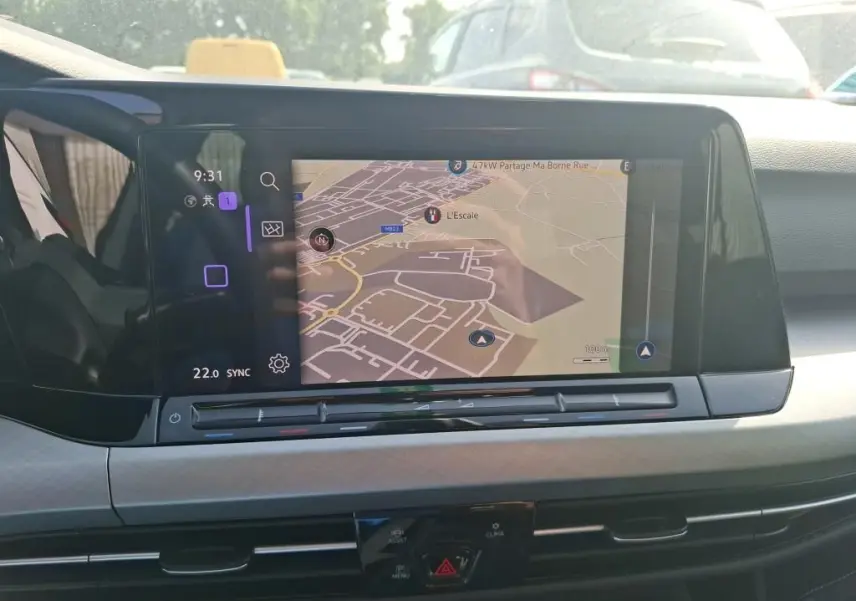 Écran tactile central affichant la navigation dans l’habitacle d’une Volkswagen Golf gris clair, vue de face.