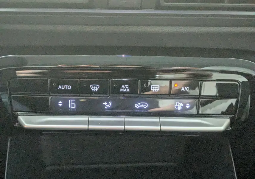 Détail du panneau de commande de la climatisation automatique de la Citroën C3 E-C3 113 MAX noire, affichant 16°C.