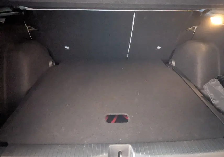 Coffre spacieux de la Citroën E-C3 113 MAX noir, vue intérieure arrière avec éclairage et tapis de sol noir.
