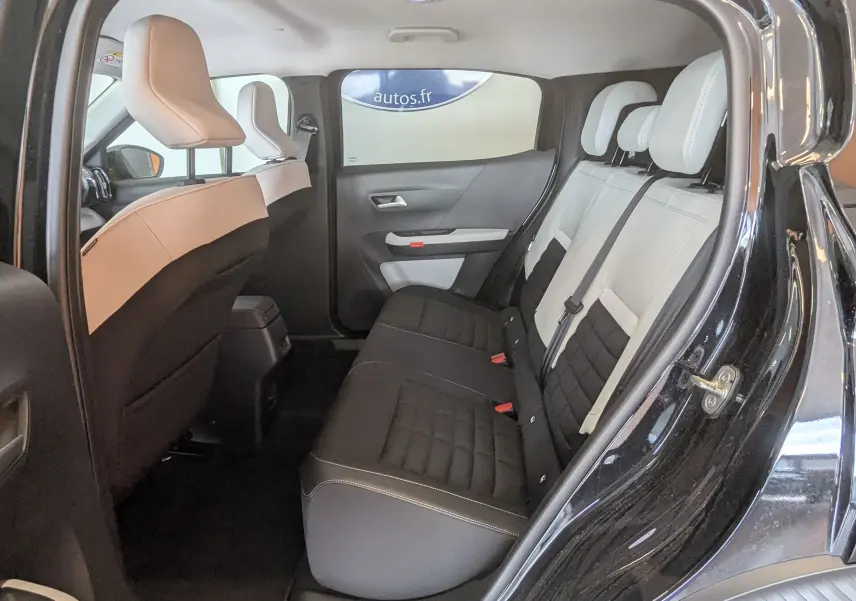 Vue intérieure côté droit des sièges arrière bicolores noir et gris clair d'une Citroën C3 E-C3 113 MAX noire, 5 portes.