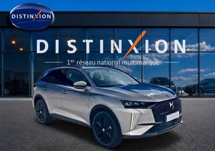 DS7 1.5 BlueHDi 130 Crystal Pearl en 3/4 avant droit, avec calandre distinctive et jantes noires devant un showroom Distinxion.