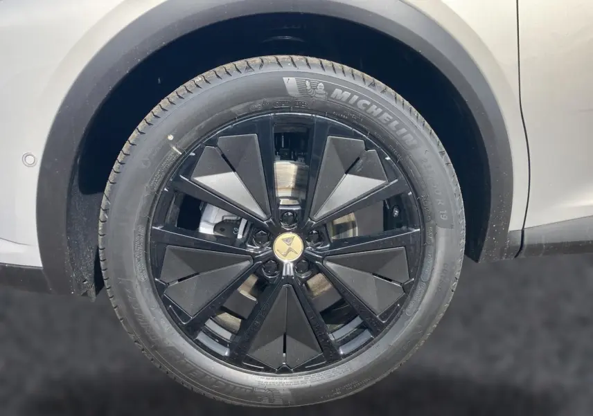 Gros plan sur la jante noire au design géométrique du DS7 Crystal Pearl, avec pneu Michelin visible.