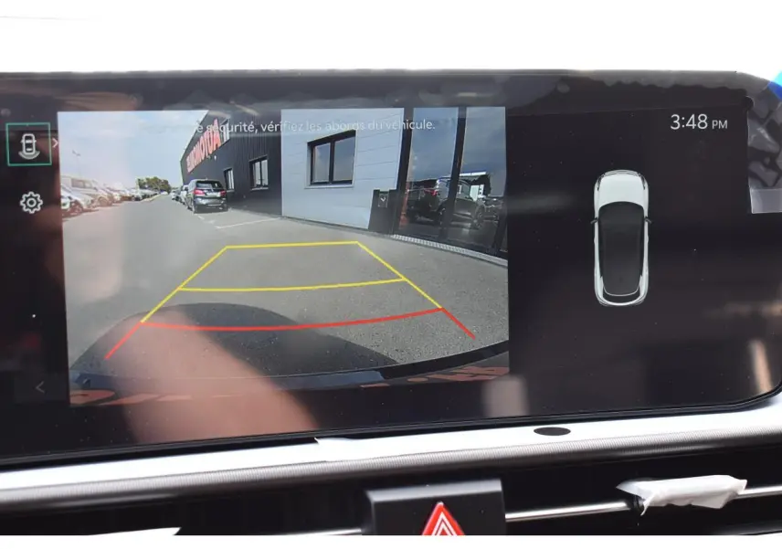 Affichage caméra de recul et vue 360° du Kia Sportage gris hybride 2026 sur écran tactile intérieur.
