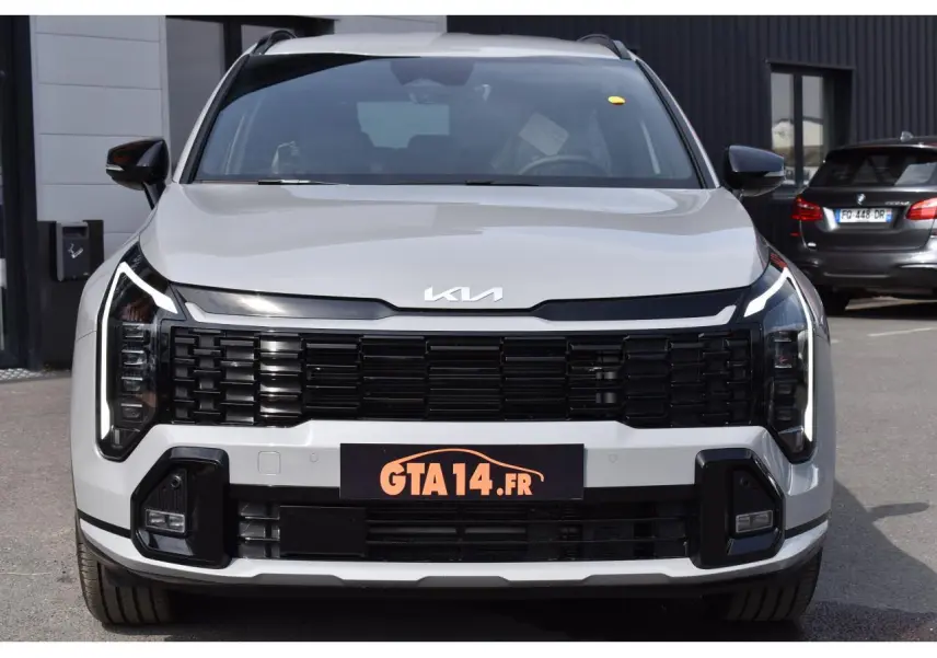 Vue de face du KIA Sportage gris 2026 avec calandre noire et feux LED verticaux distinctifs.