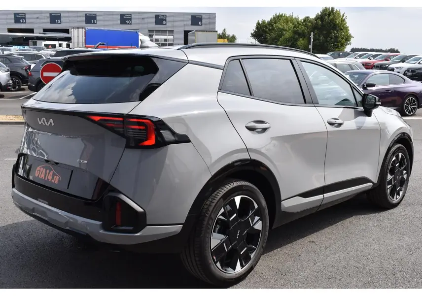 Vue 3/4 arrière droite du KIA Sportage hybride gris avec jantes noires et feux arrière LED distinctifs.