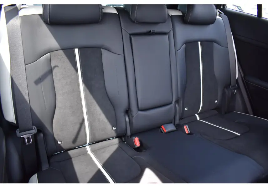 Vue rapprochée des sièges arrière bi-ton noir et gris du Kia Sportage hybride 2026 avec ceintures visibles.