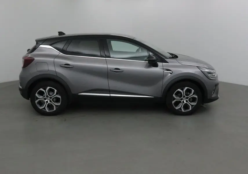 Profil droit du Renault Captur 2024 gris Cassiopée avec toit noir et lignes chromées élégantes.
