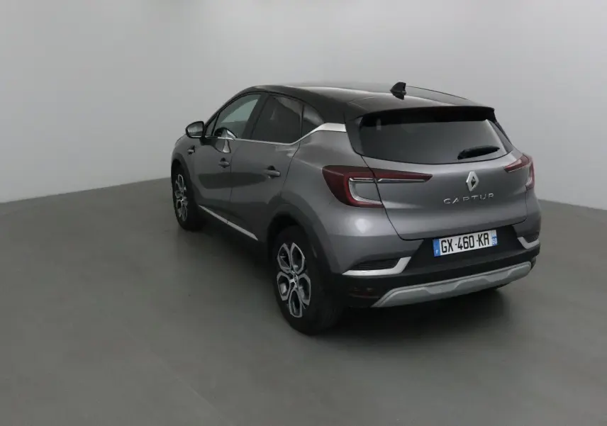 Renault Captur 2024 gris Cassiopée et noir, vue 3/4 arrière droit, avec feux arrière LED et jantes alliage 18 pouces.