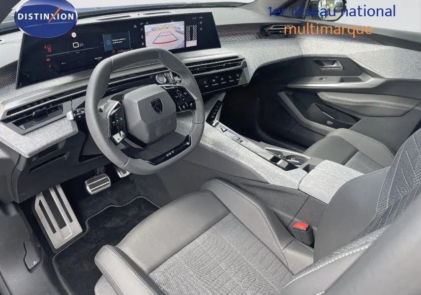Intérieur du Peugeot 5008 Hybrid 2025 vu côté conducteur, avec tableau de bord numérique et sellerie cuir gris clair.