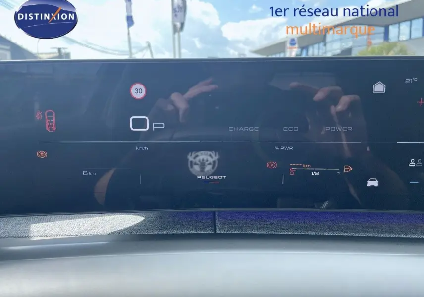 Tableau de bord numérique du Peugeot 5008 Hybrid 2025 affichant la vitesse, autonomie et mode de conduite en noir brillant.