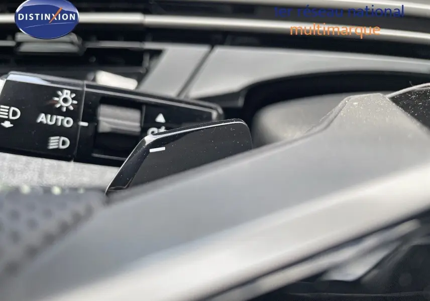 Gros plan sur la commande des feux et la palette de changement de vitesse du Peugeot 5008 noir perle métal 2025.