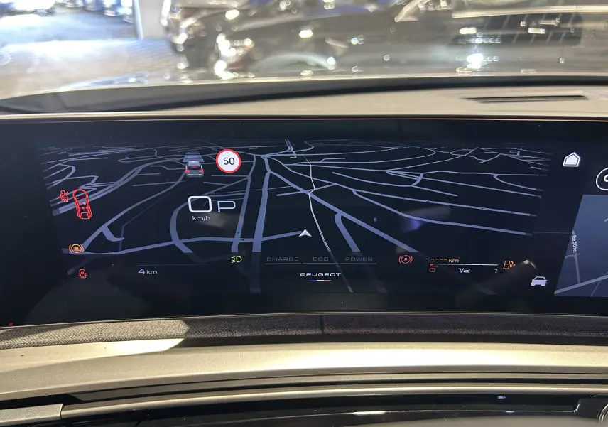 Vue intérieure du tableau de bord numérique du Peugeot 3008 gris Artense, affichant la navigation et les informations de conduite.