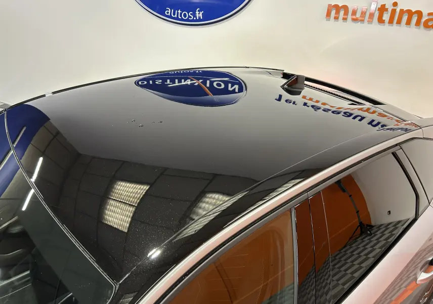 Toit panoramique noir brillant du Peugeot 3008 gris Artense, vue en léger plongée côté gauche avec reflet intérieur et extérieur.