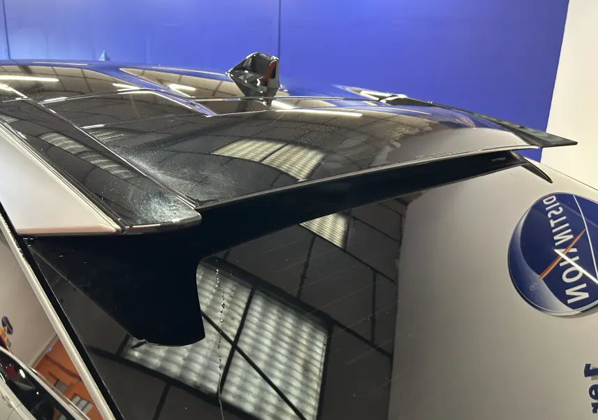 Gros plan sur l'aileron arrière noir du Peugeot 3008 gris Artense, avec toit panoramique et antenne requin visible.