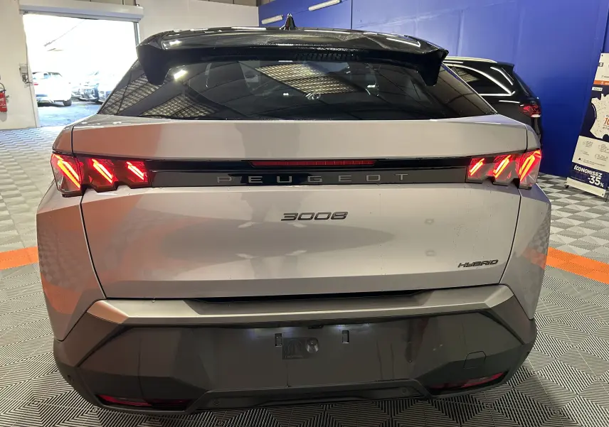 Vue arrière d’un Peugeot 3008 gris Artense avec feux LED allumés dans un garage intérieur.