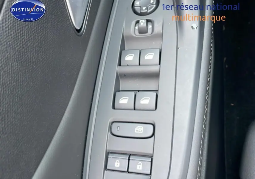 Vue rapprochée des commandes des vitres et des serrures sur la porte côté conducteur d’une Peugeot 308 noire 2025.