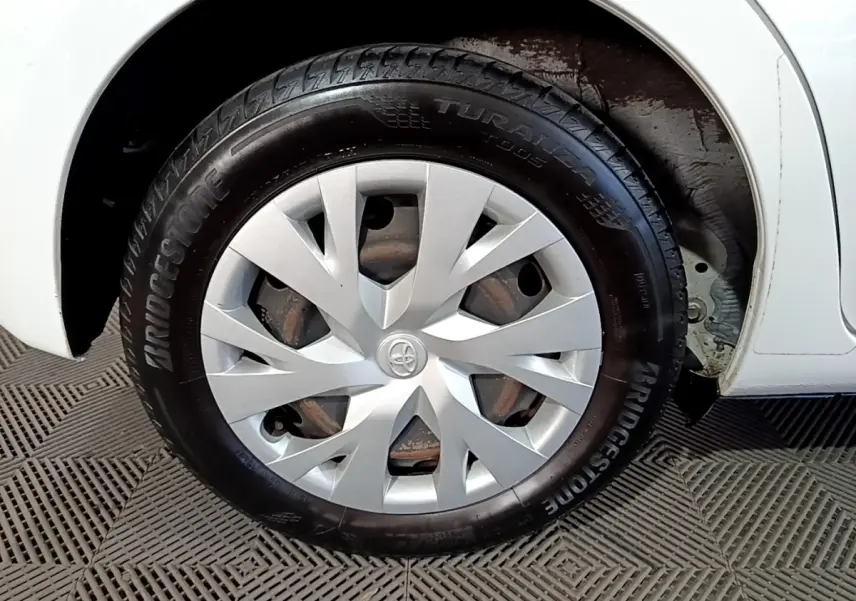 Gros plan sur la roue avant droite blanche d’une Toyota Yaris 1.5 Hybride avec enjoliveur argenté et pneu Bridgestone.