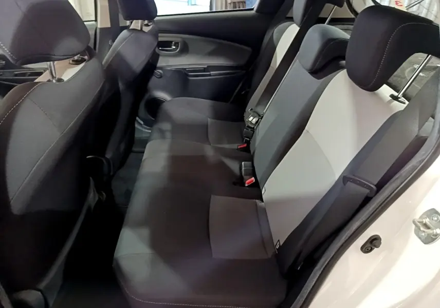 Vue intérieure côté droit des sièges arrière bicolores gris et noir de la Toyota Yaris 1.5 Hybride 2020 blanche.