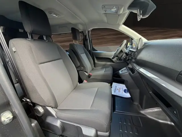 Vue intérieure côté droit du Citroën Jumpy 2026, sièges tissu bi-ton noir-gris et tableau de bord moderne.