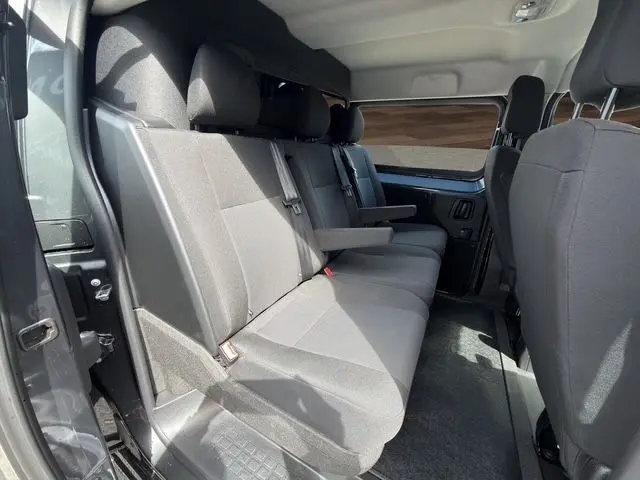 Vue intérieure côté gauche des sièges arrière gris du Citroën Jumpy 2026 avec habillage bois visible sur la cloison.