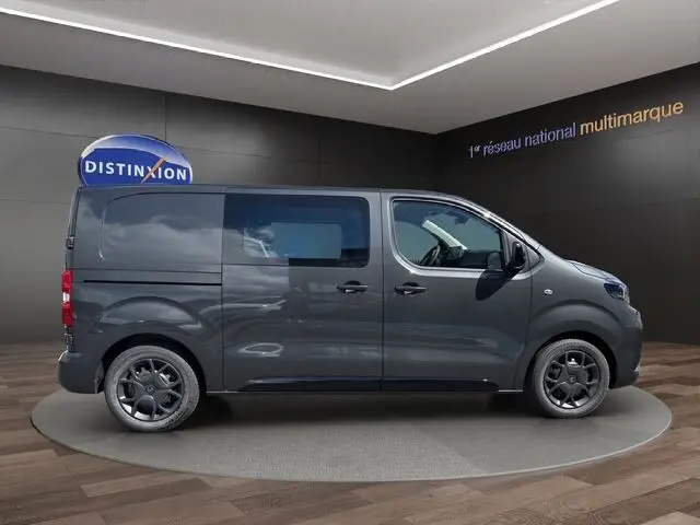 Vue latérale droite d'un Citroën Jumpy gris titane avec jantes noires et porte latérale coulissante.